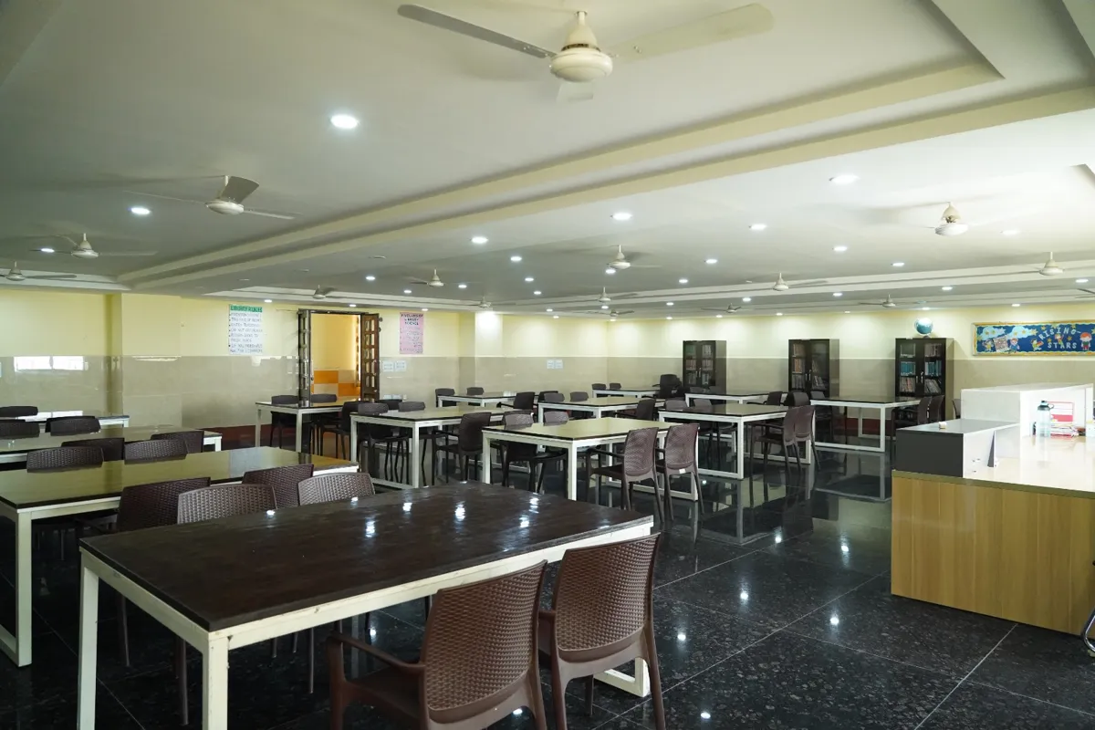 School library with reading tables, chairs, book cabinets and the librarian’s desk