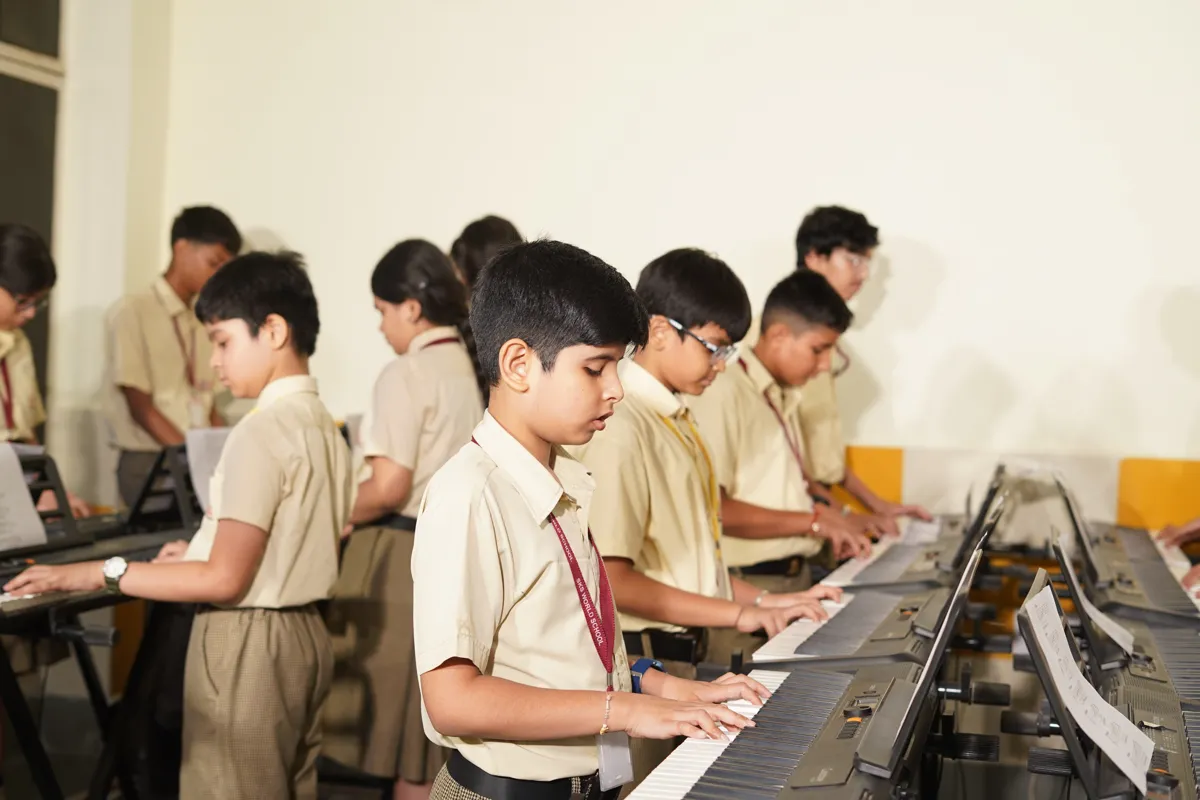 Students playing keyboards in the music room at SKS World School, Greater Noida West
