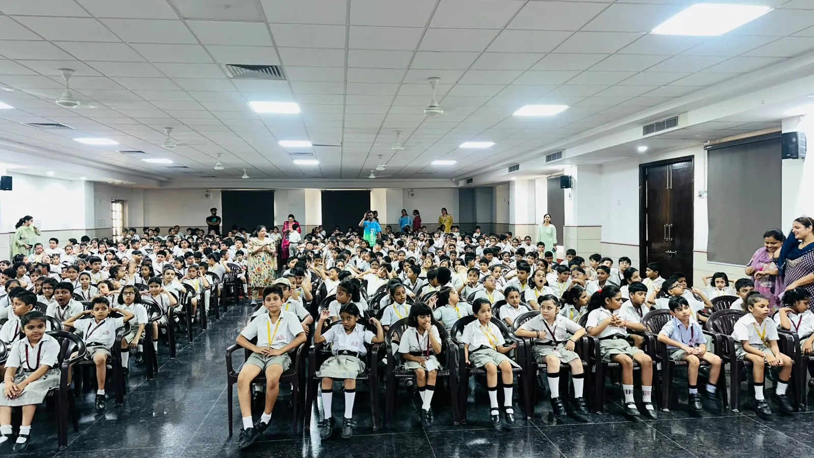 Junior students seated for an assembly in the auditorium at SKS World School, Greater Noida West