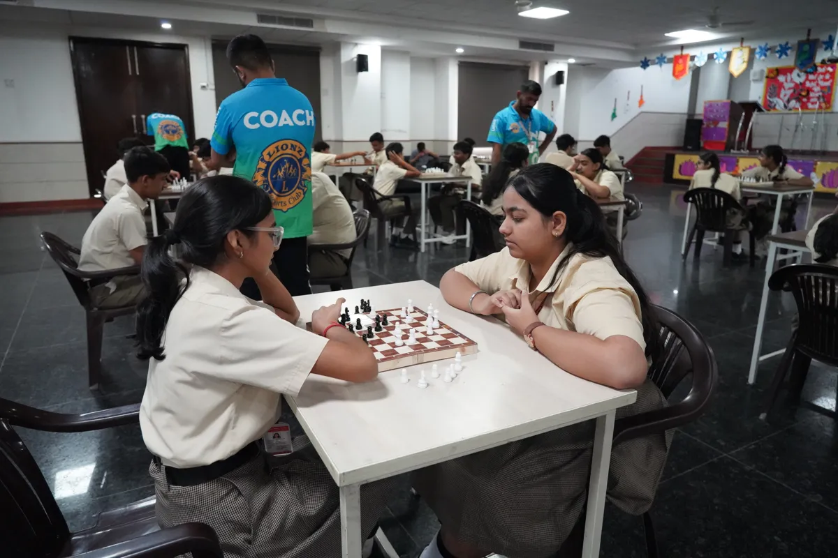 Students playing chess with a coach in the activity hall, SKS World School, Greater Noida West