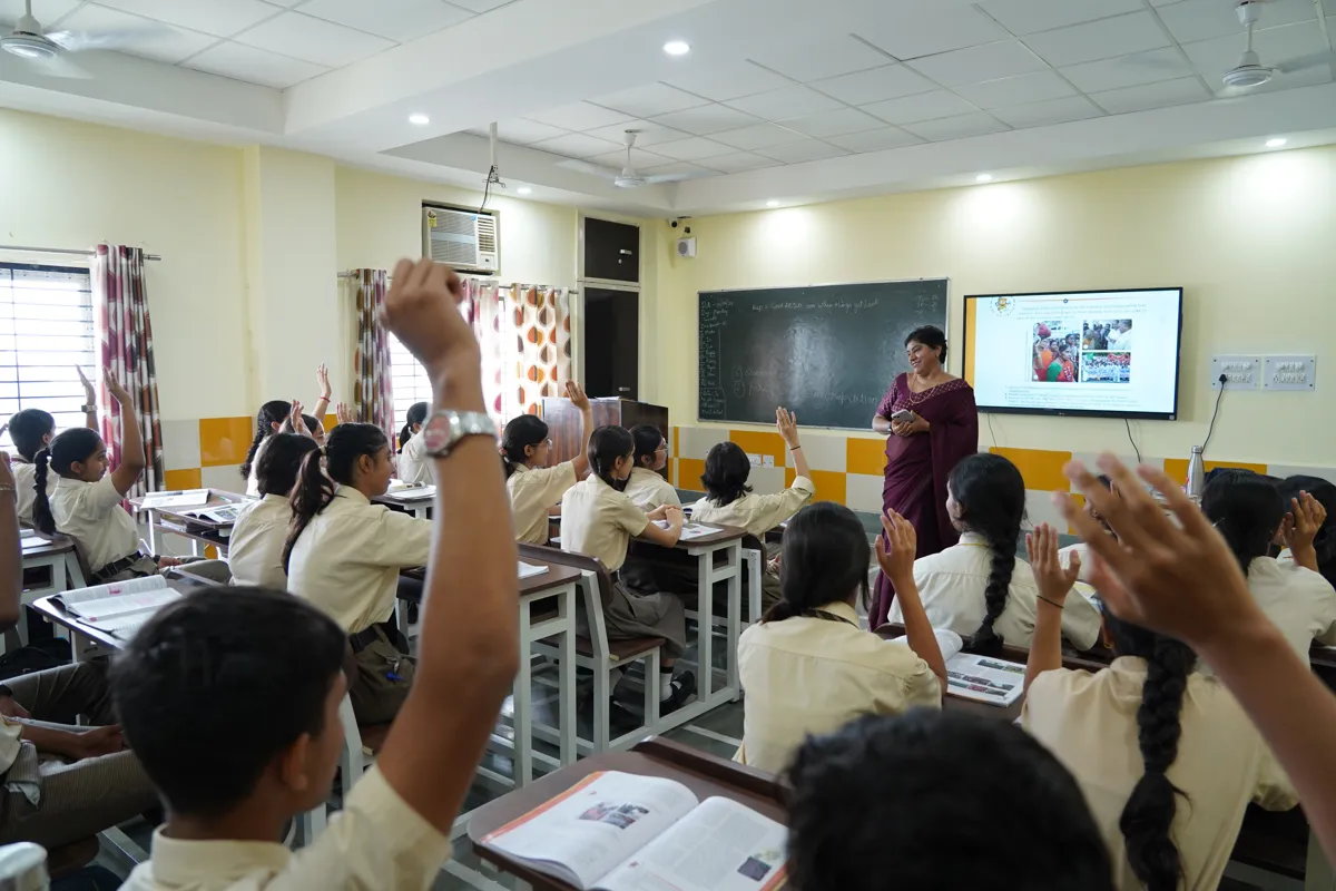 Students raising their hands during a smart-board lesson, SKS World School, Greater Noida West