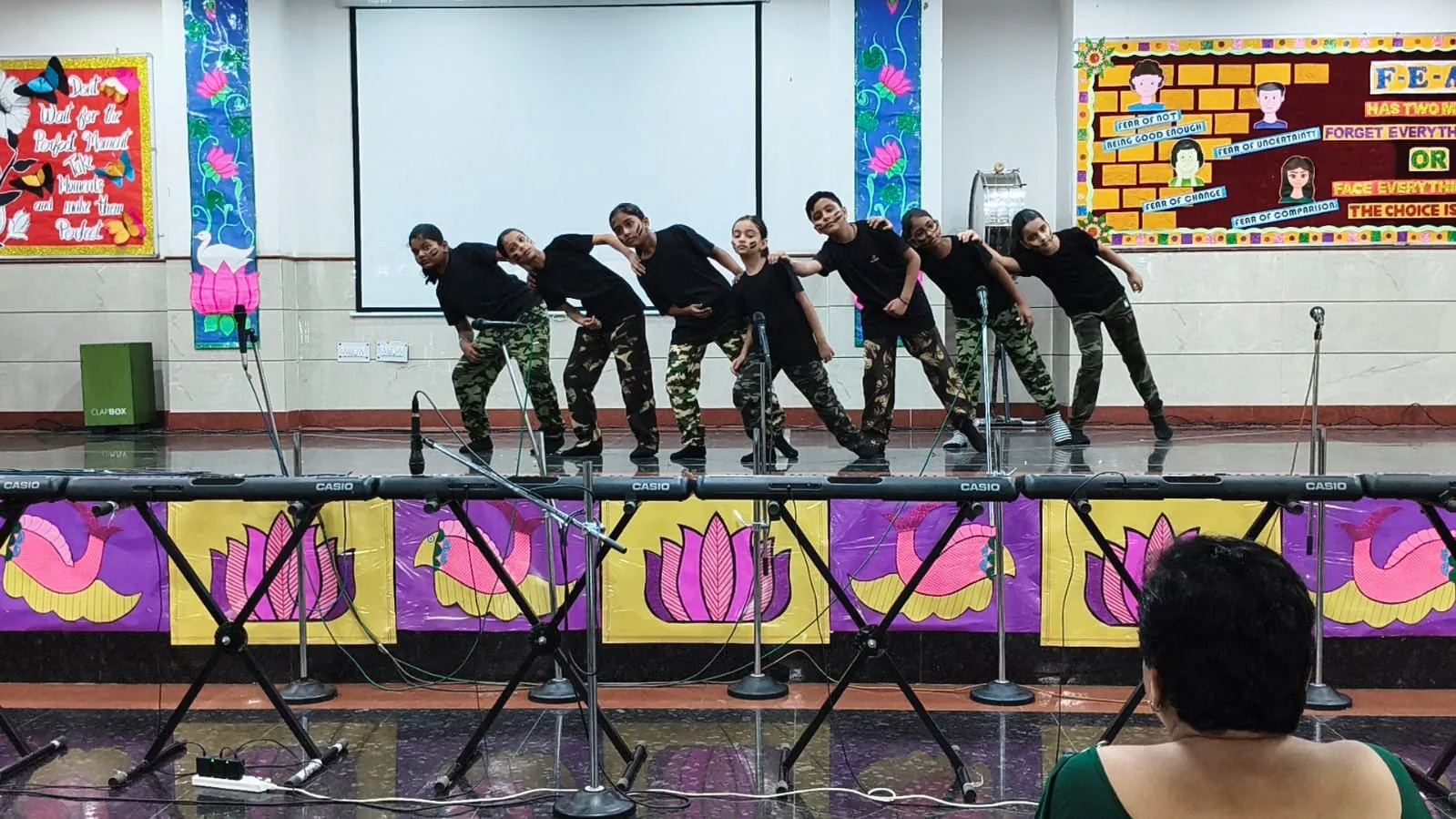 Students in camouflage outfits performing a dance on stage at SKS World School, Greater Noida West