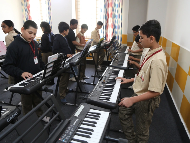 Students playing keyboards in the music class at SKS World School, Greater Noida West