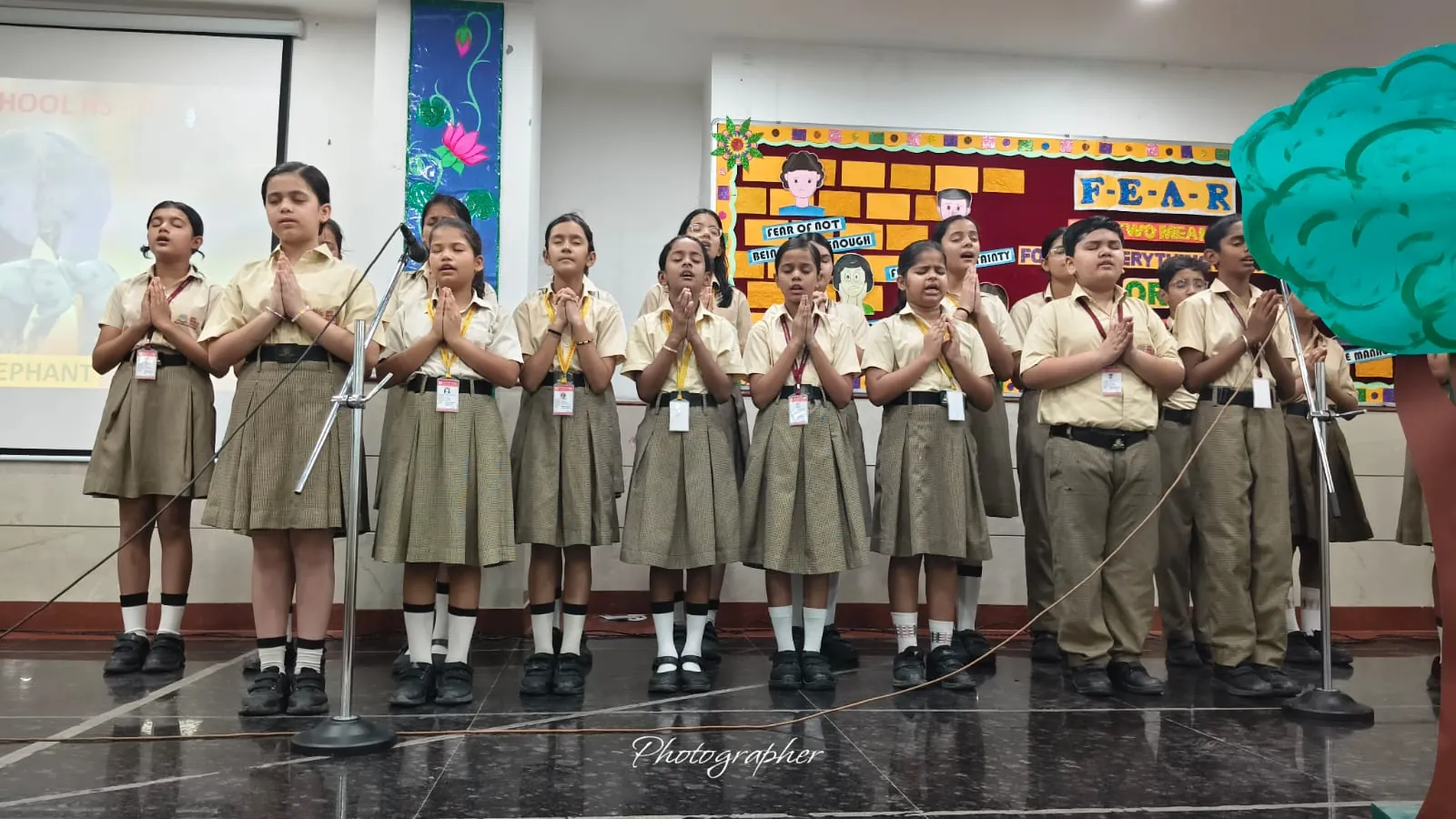 Students singing a prayer on the auditorium stage at SKS World School, Greater Noida West