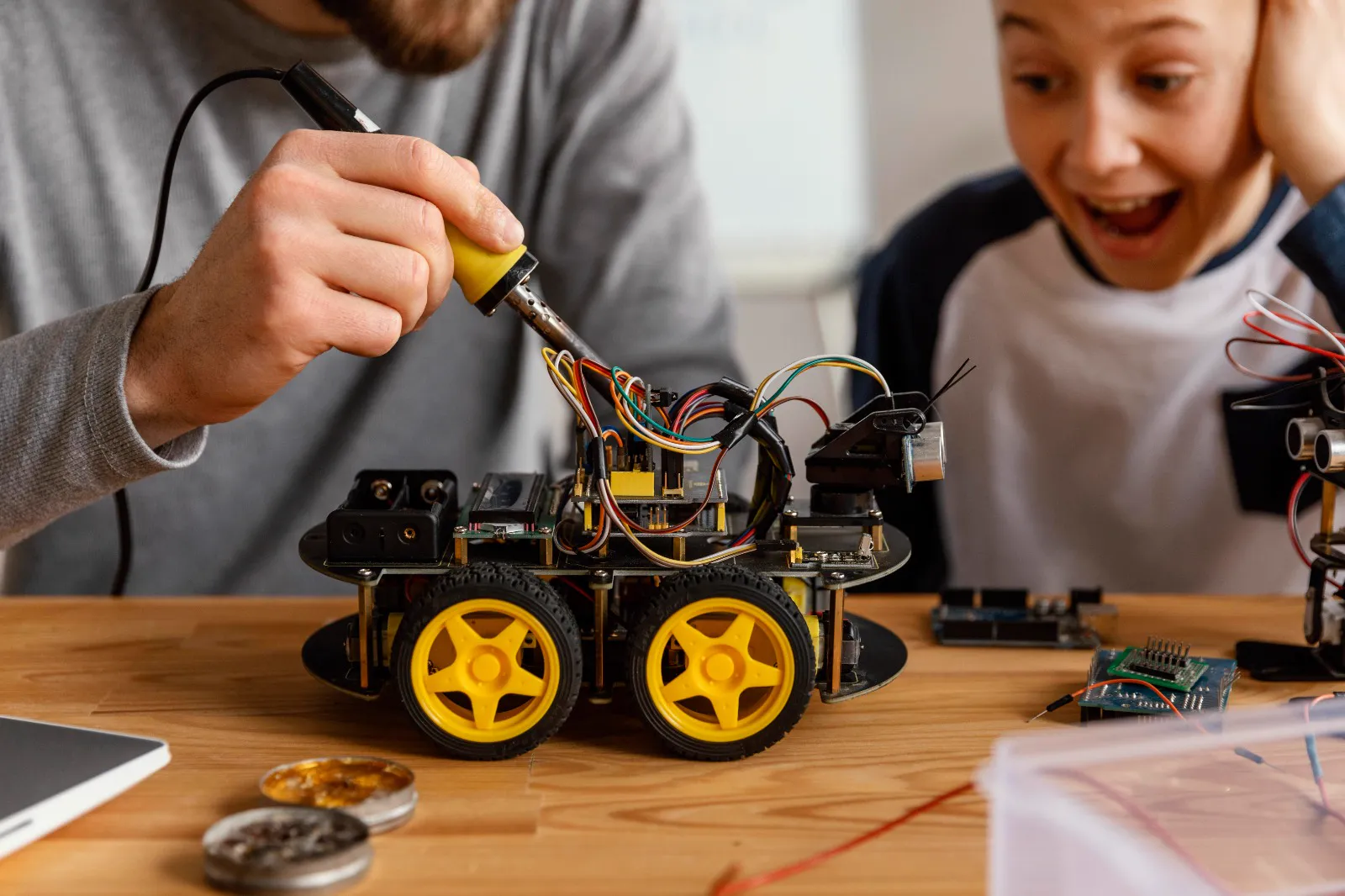 Student watching a robot car being built in a robotics session