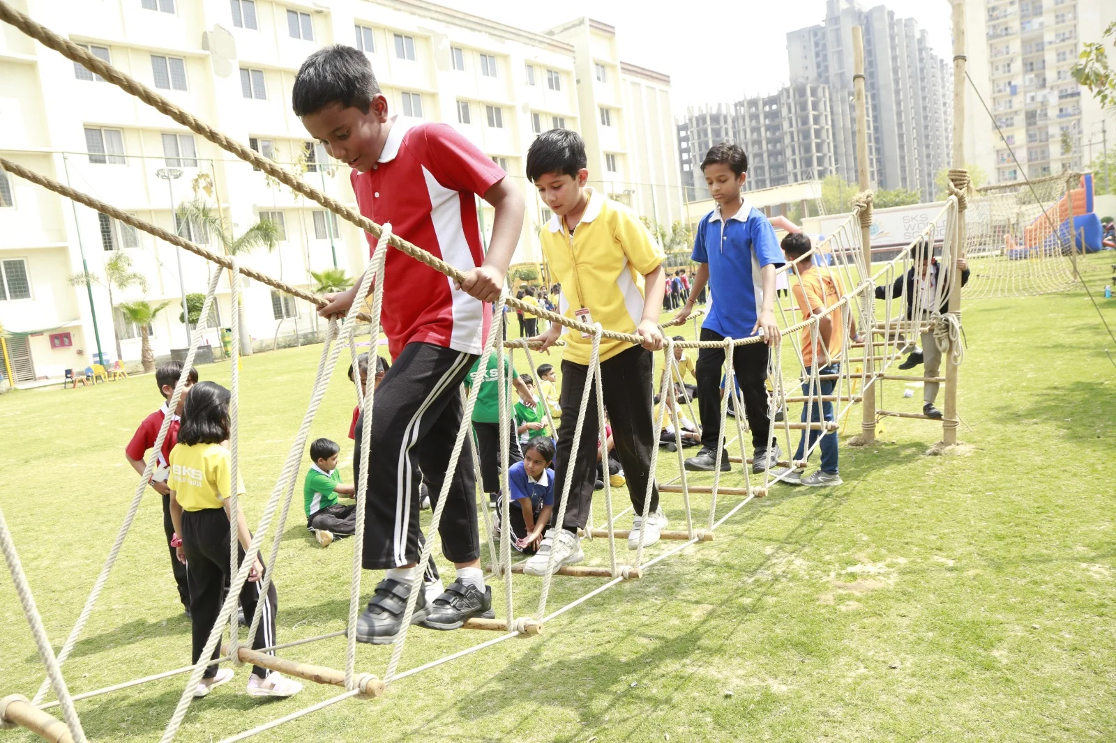 Primary students of SKS World School, Greater Noida West crossing a rope bridge during adventure activities