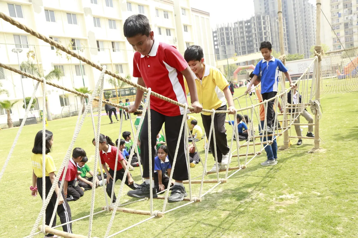 Students crossing a rope bridge during adventure activities at SKS World School, Greater Noida West