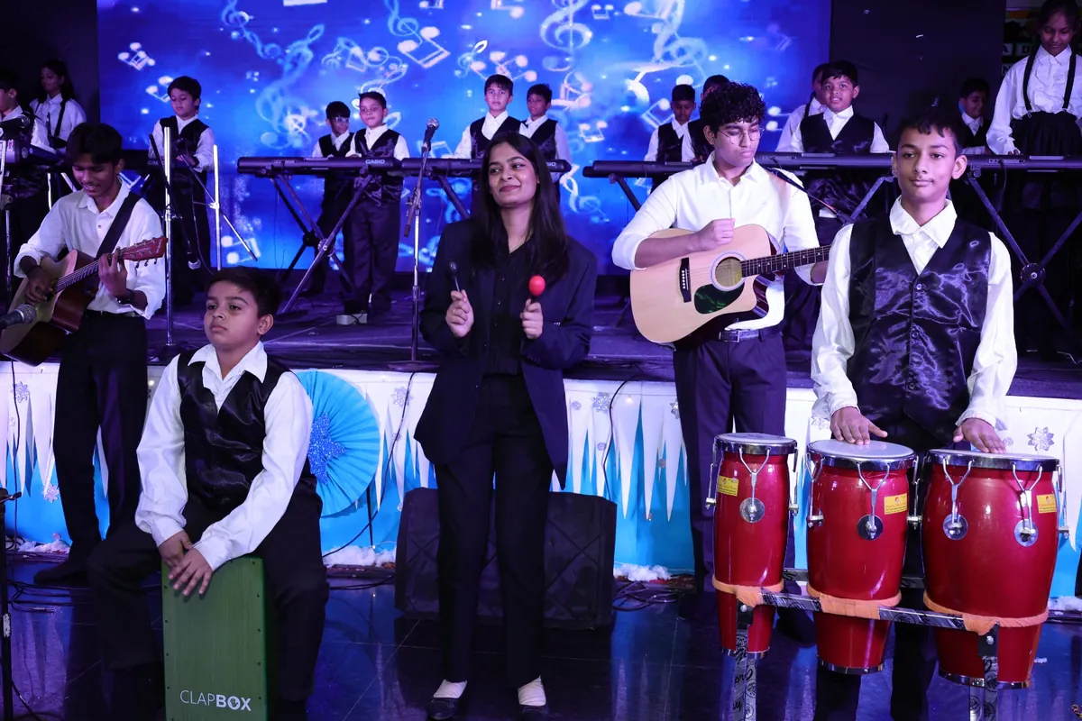 Student band performing with guitar, keyboard and congas on the Annual Day stage at SKS World School, Greater Noida West