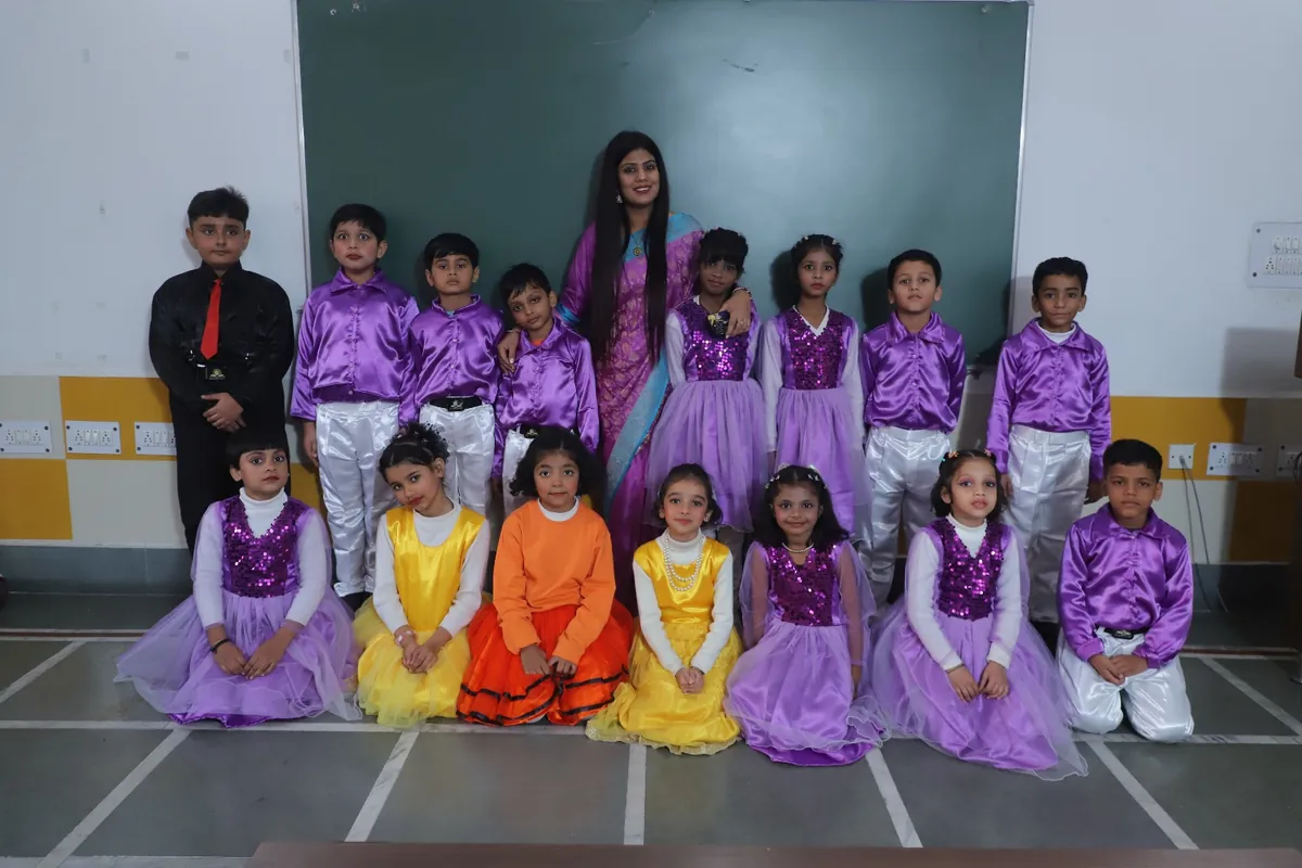 Students in purple and gold Annual Day costumes with their teachers at SKS World School, Greater Noida West