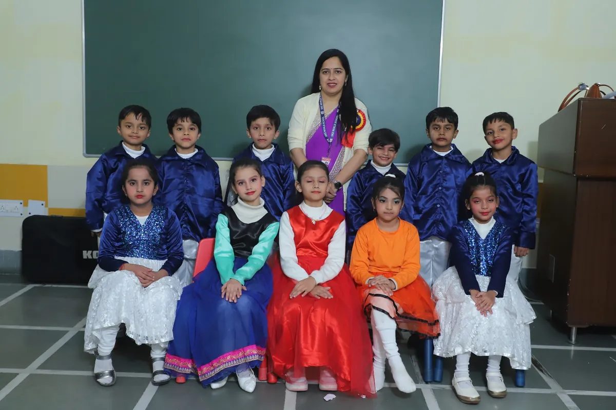 Students in colourful folk costumes for Annual Day with their teacher at SKS World School, Greater Noida West