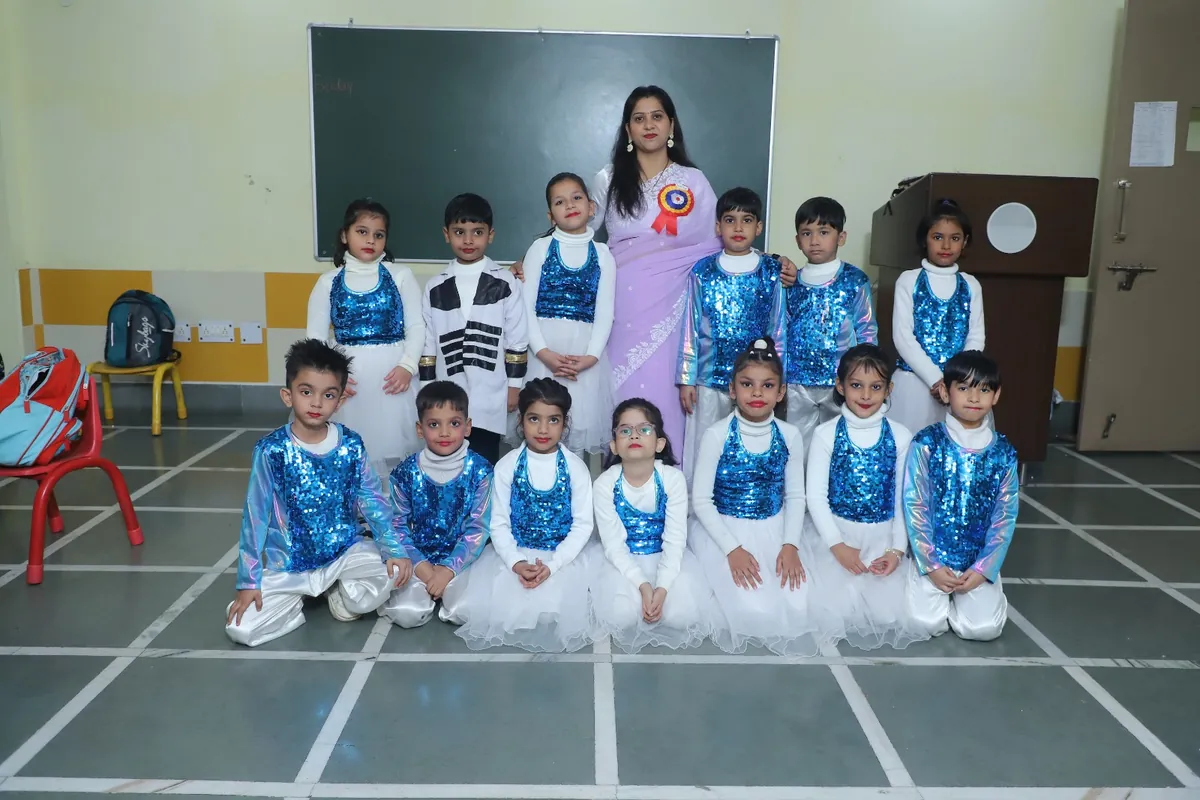 Students in blue sequinned Annual Day costumes with their teacher at SKS World School, Greater Noida West