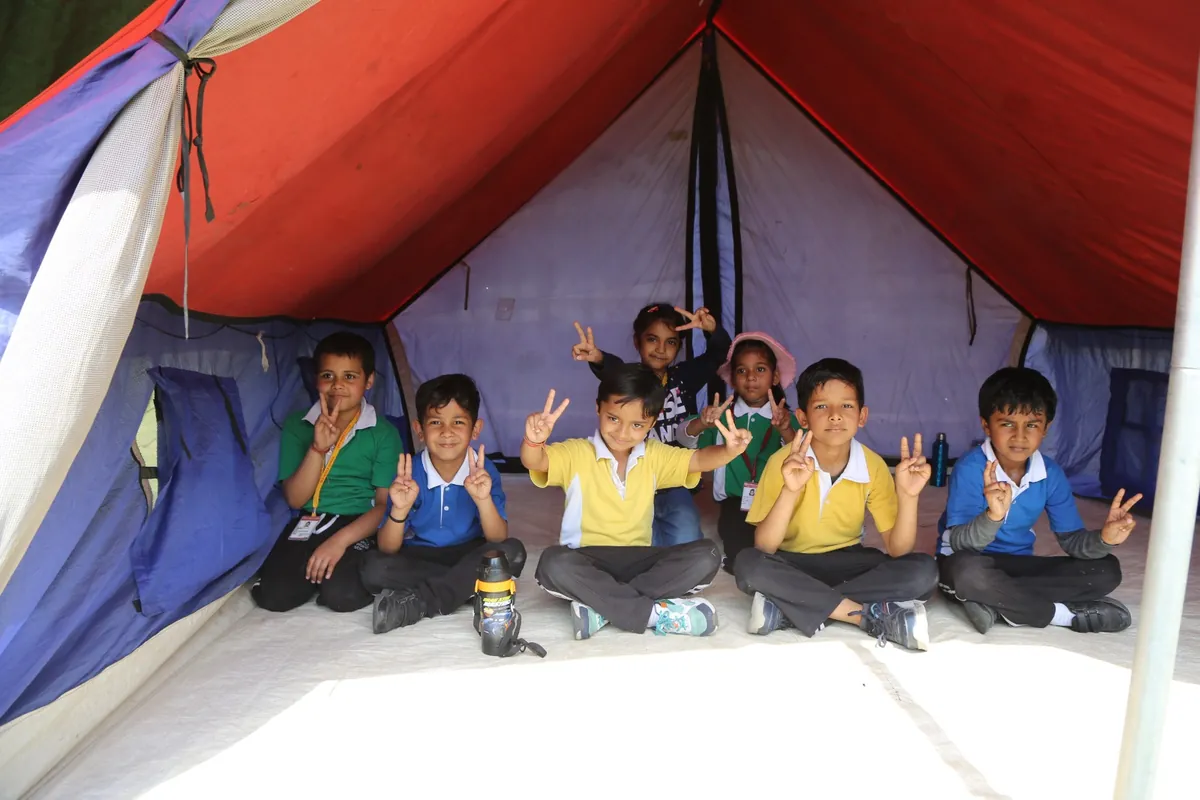Students smiling inside a camping tent at SKS World School, Greater Noida West