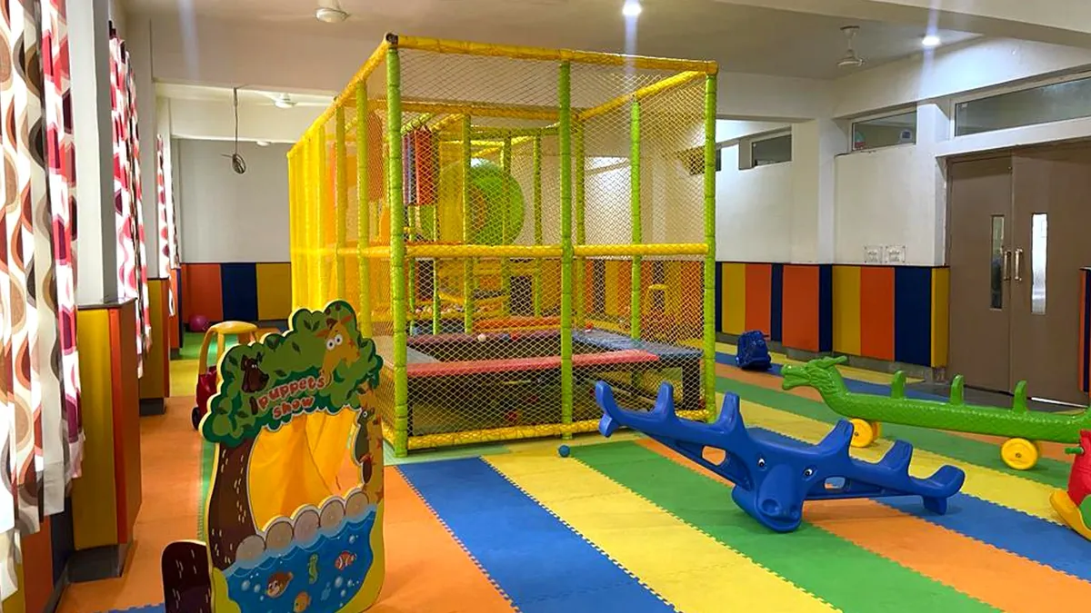 Indoor play zone with a climbing frame, seesaws and soft flooring at SKS World School, Greater Noida West