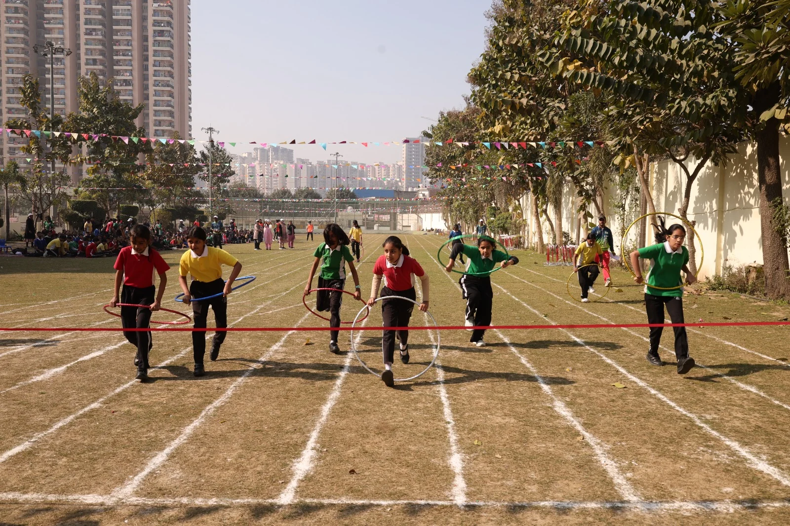 Middle-school students of SKS World School, Greater Noida West running a hoop race on Sports Day