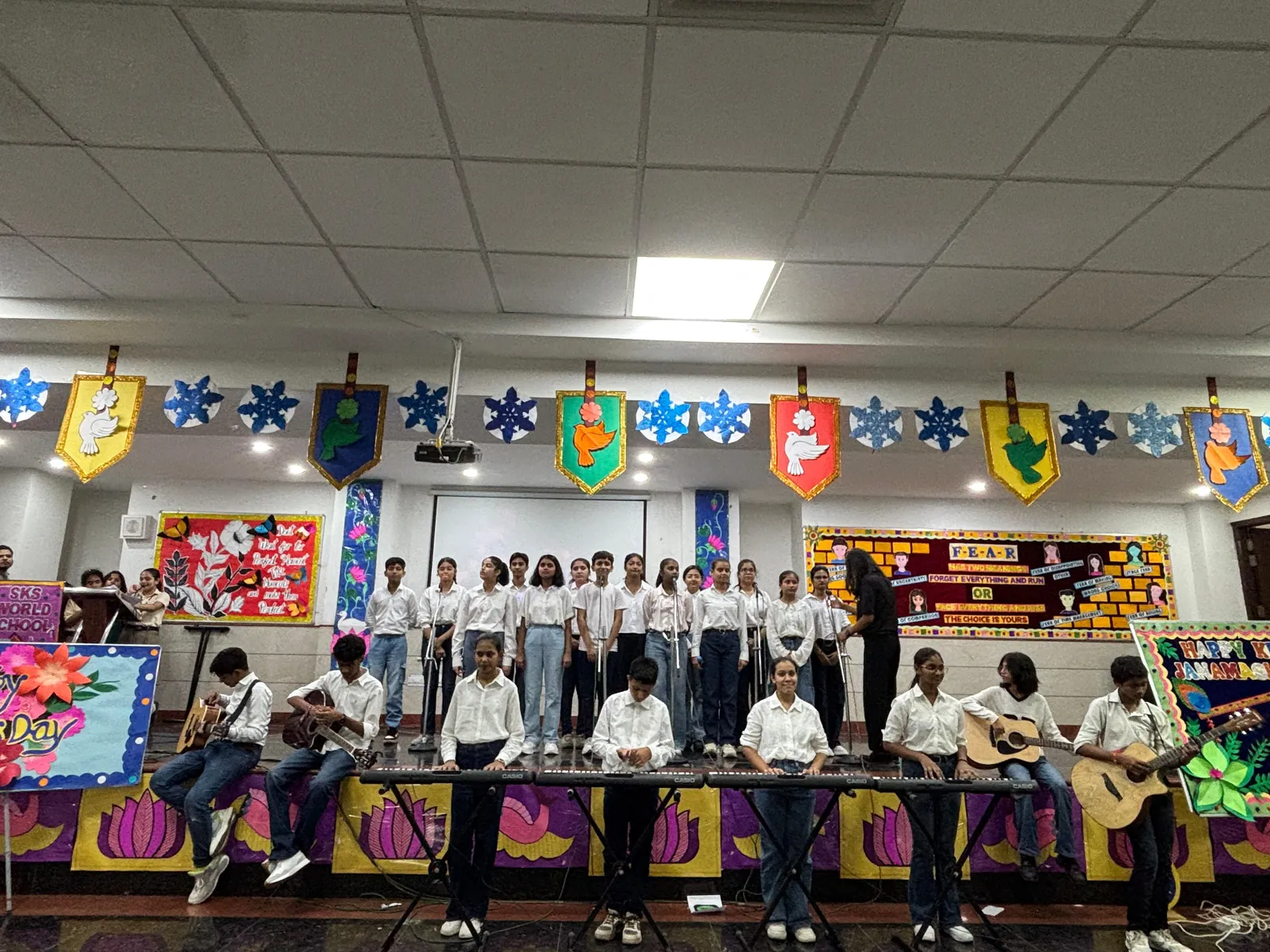 Student choir with keyboards and guitars performing on stage at SKS World School, Greater Noida West