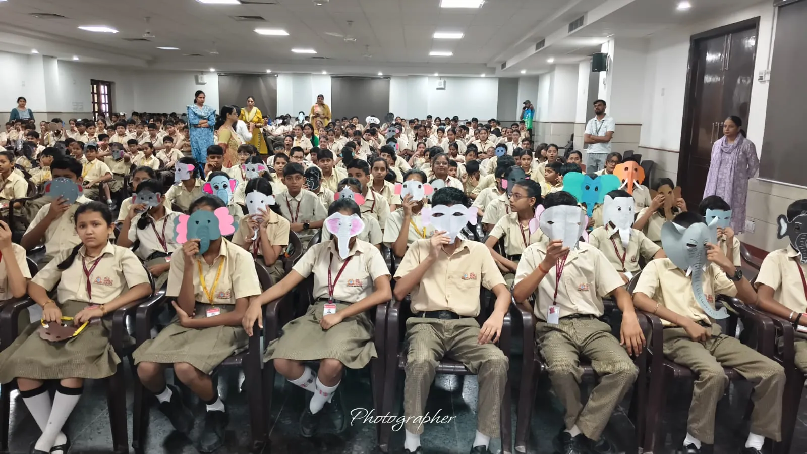 Students holding elephant masks in the auditorium at SKS World School, Greater Noida West
