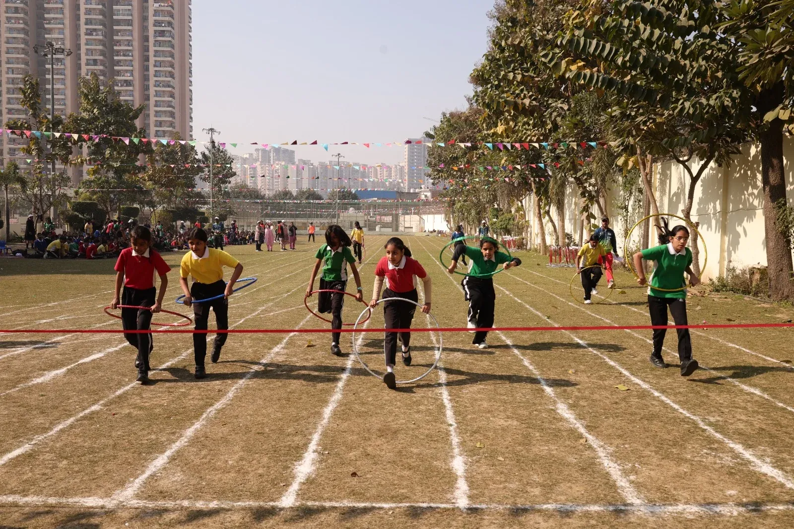 Middle-school students of SKS World School, Greater Noida West running a hoop race on Sports Day